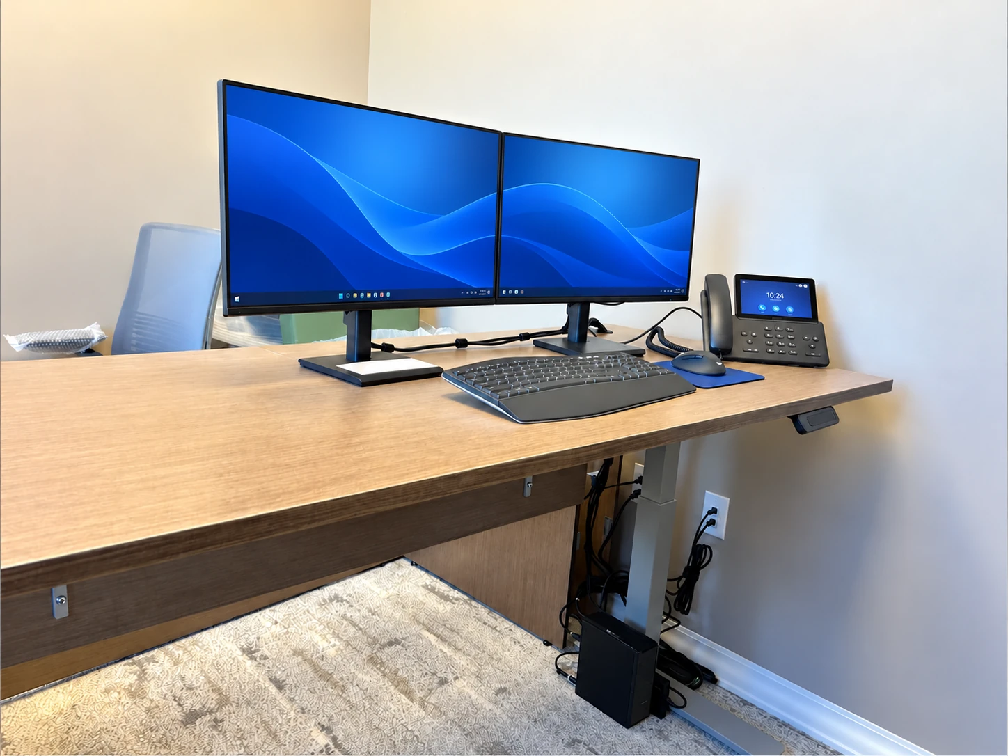Medical office workstation with a phone and powered-on monitors
